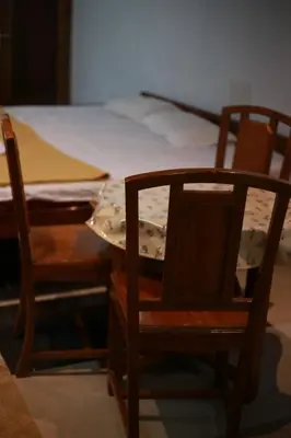 two wooden chairs and a table with a bed at Dreams Valley in Kadavoor