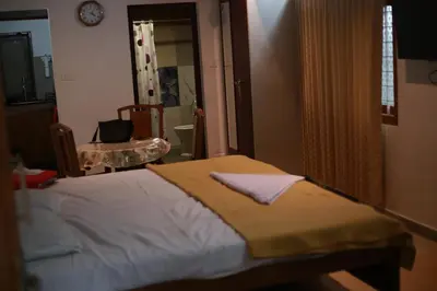 a bedroom with a bed and a chair and a mirror at Dreams Valley in Kadavoor