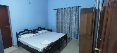 a bedroom with two beds and a blue wall at Blooms Aquatica in Kenichira
