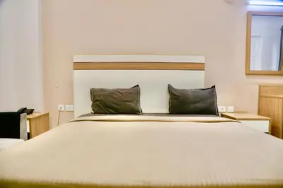 a bedroom with a large white bed with two pillows at Virksham Hotel in Coimbatore