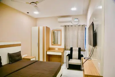 a small bedroom with a bed and a chair at Virksham Hotel in Coimbatore