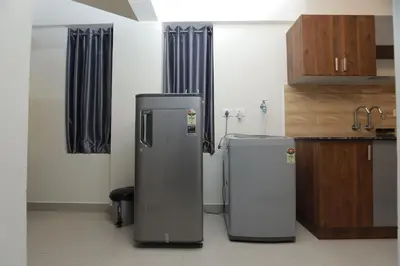 two refrigerators are sitting in a kitchen at Laura Airport Suits & Apartments in Nedumbassery