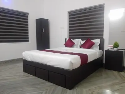 a bedroom with a large bed with red pillows at calicut residency in Kozhikode