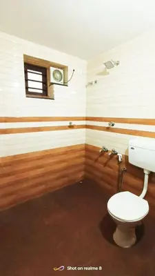 a bathroom with a white toilet and a window at calicut residency in Kozhikode