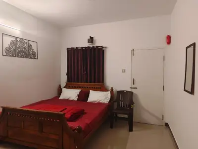 a bedroom with a red bed and a chair at Jazz&Hill in Kodaikānāl