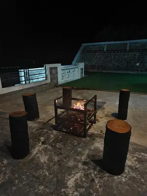 a fire pit in a courtyard at night at Jazz&Hill in Kodaikānāl