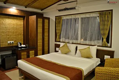 a bedroom with a bed and a desk and a window at Sepoy Grande Mysore in Mysore