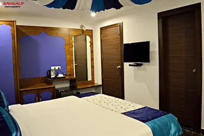 a hotel room with a bed and a tv at Sepoy Grande Mysore in Mysore