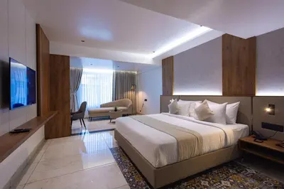 a hotel room with a bed and a living room at Royal Plaza Inn by RAK Rooms, Calicut in Kozhikode