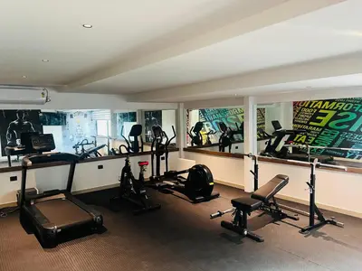 a gym with several treadmills and exercise equipment in a room at Royal Plaza Inn by RAK Rooms, Calicut in Kozhikode