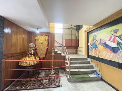 a staircase in a building with a painting on the wall at Hotel SilverLine Regency Munnar in Munnar