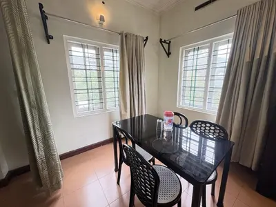 a dining room with a black table and chairs at Hotel SilverLine Regency Munnar in Munnar