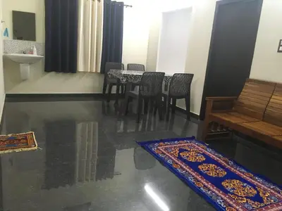 a dining room with a table and chairs and a rug at Peaceful perch in Kozhikode