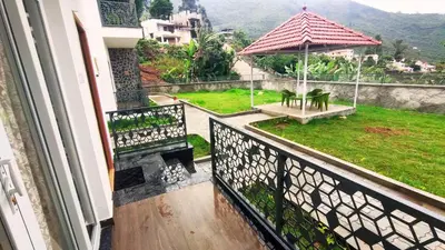 a balcony of a house with a view of a garden at Banana Tree Retreat in Kodaikānāl