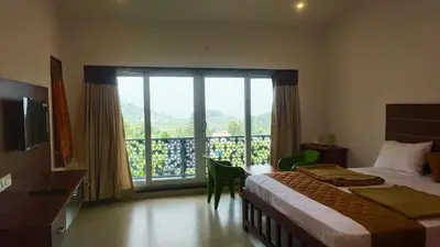 a hotel room with a bed and a large window at Banana Tree Retreat in Kodaikānāl
