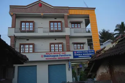 a tall white building with a lot of windows at Athira Residency Coorg in Kushālnagar