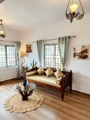 a living room with a couch and a glass table at Urban Lush in Ooty