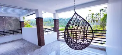 a swing hanging from a balcony with a view at Sands Villa Homestay in Wayanad