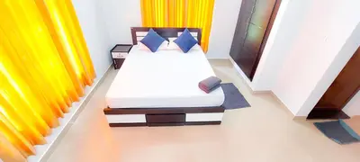 a bed in a room with colorful curtains at Sands Villa Homestay in Wayanad