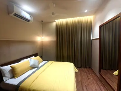a bedroom with a large bed with yellow sheets at Gulzar 1BHK Service Apartment, kannur in Kannur