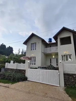 a white house with a white fence at FN's Eternia in Ooty