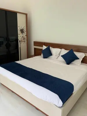 a bedroom with a large bed with blue pillows at KiwiOz Villa in Thamarassery