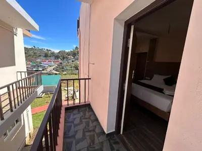 a room with a balcony with a bed and a bed gmaxwell gmaxwell gmaxwell at Rio Grande Retreat in Kodaikānāl