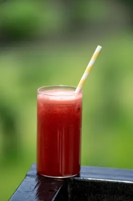 a drink with a straw sitting on a table at Yanai at Anai - Private Pool & Private Cook in Varagampadi