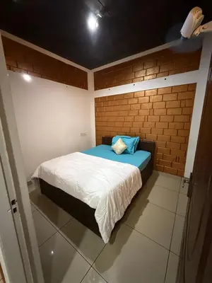 a bedroom with a bed with a brick wall at JOHNS VILLAGE Resorts in Vallikavungal
