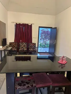 a room with a table and chairs and a window at Kashmir Valley Alpha in Kanthalloor