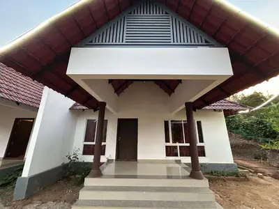 a small white house with a large roof at Kashmir Valley Alpha in Kanthalloor
