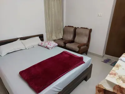 a bedroom with a large bed and a chair at Real Estate GURUVAYOOR in Trichūr
