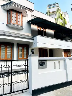 a white house with a black fence at Real Estate GURUVAYOOR in Trichūr