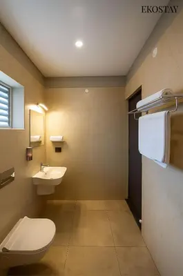 a bathroom with a toilet and a sink at EKOSTAY - Amber Villa in Kodaikānāl