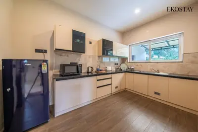 a large kitchen with a refrigerator and a window at EKOSTAY - Amber Villa in Kodaikānāl