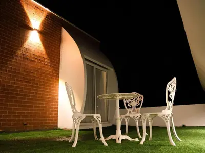 two chairs and a table in a yard at night at Talenresort Vythiri Villas in Wayanad