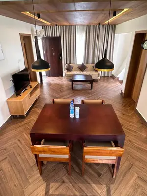 a living room with a table and a couch at Talenresort Vythiri Villas in Wayanad