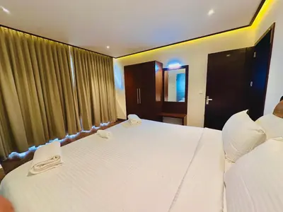 a bedroom with two white beds and a window at Talenresort Vythiri Villas in Wayanad