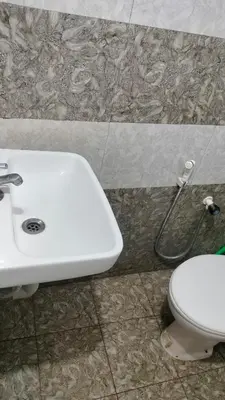 a bathroom with a white sink and a toilet at Aswathy Bhavan in Vadakkāncheri