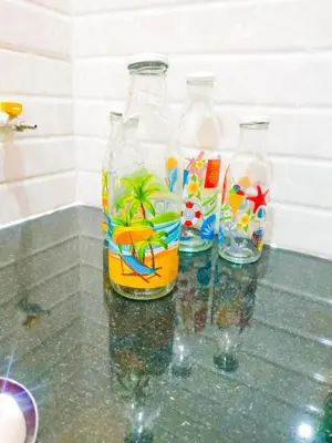 three glass bottles sitting on a counter top with at Tranquil Traditions Homestay - Inspired by Nature & Heritage in Mysore