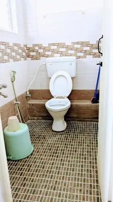 a bathroom with a toilet in a room at PALLIYARAI GARDENS LODGE AND HOMESTAy in Palani