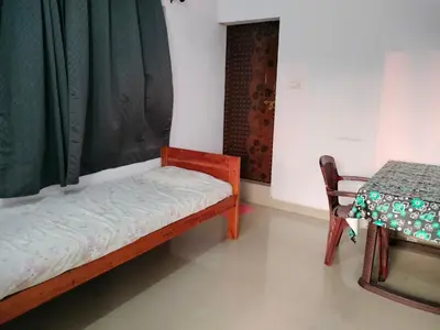 a small room with a bed and a table at Aswathy Bhavan in Palakkad