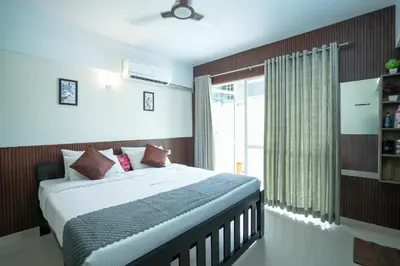 a bedroom with a large bed with a window at Sancta Maria Lounge -cochin Airport in Nedumbassery