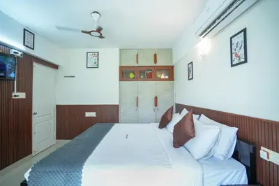 a bedroom with a bed with white sheets and pillows at Sancta Maria Lounge -cochin Airport in Nedumbassery