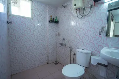 a bathroom with a toilet and a sink at Sancta Maria Lounge -cochin Airport in Nedumbassery
