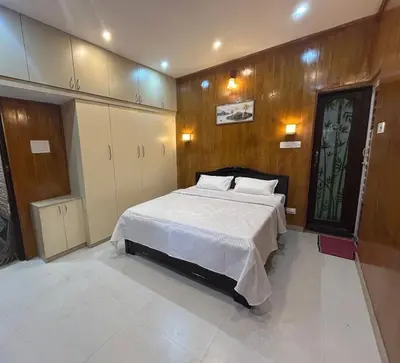 a bedroom with a large bed with wooden walls at Franklin's Finestay in Kotagiri