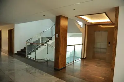 a hallway with a glass staircase in a building at Marina Tower & Regency Changaramkulam in Edappāl