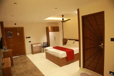 a bedroom with a bed with a red blanket at Marina Tower & Regency Changaramkulam in Edappāl