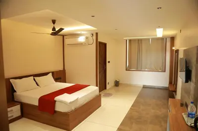 a bedroom with a bed with a red blanket at Marina Tower & Regency Changaramkulam in Edappāl