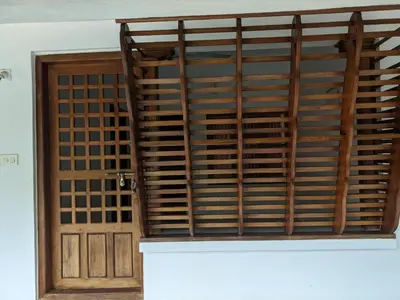 an open door with wooden shutters in a room at Milu Homes in Thirunelli